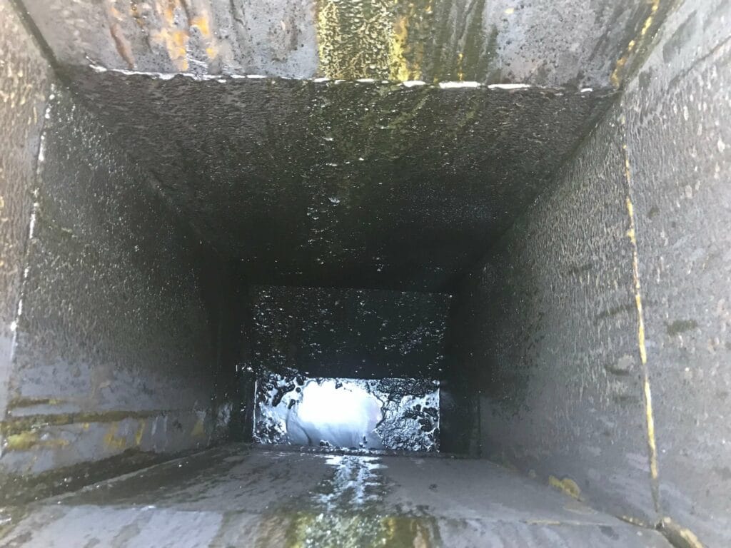 Grease buildup inside a commercial kitchen exhaust duct before cleaning